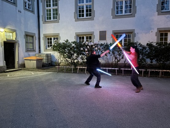 Two people training with light sabres