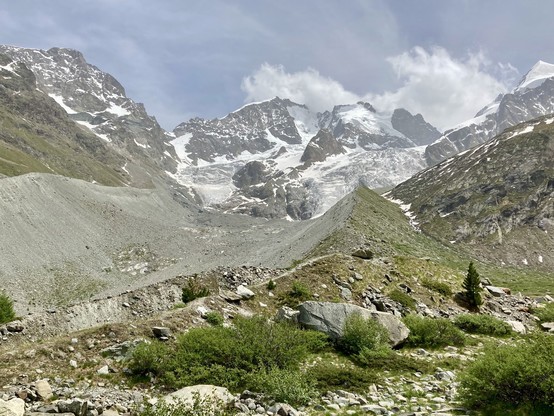 Blick über ein leeres Gletscherkar auf die dahinterliegende Berninagruppe.