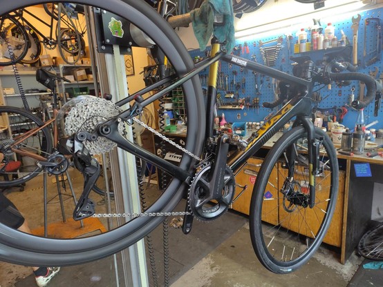 Ein geputzes Rennrad in einem Montageständer in einer Fahrradwerkstatt.